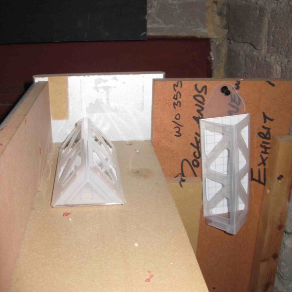Two demi-diamond clothes moth traps with pheromone lures. One attached vertically to a wall, the other flat on a shelf.
