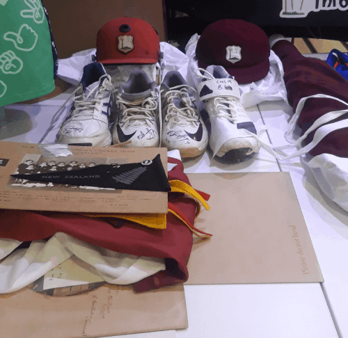 Piles of cricket caps, shoes and photos